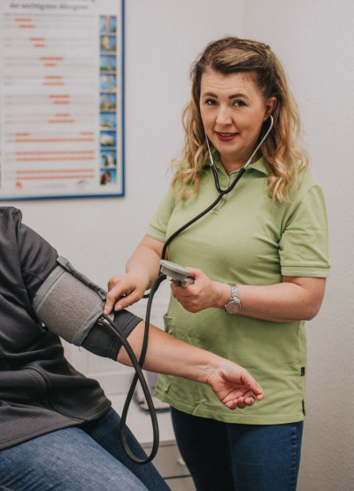 Bild 07 - Mitarbeiterin mit Blutdruck am Patienten.jpg